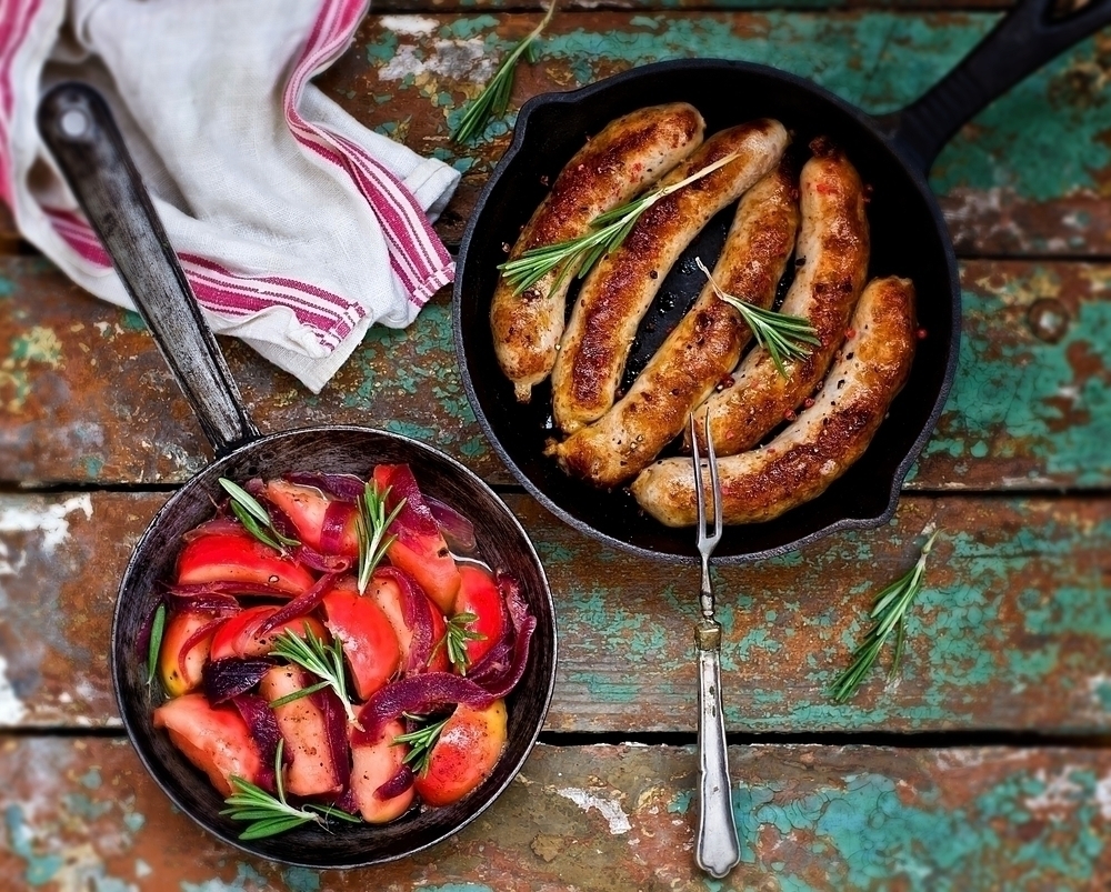 Freshly cooked sausages and tomato dish, still in pan