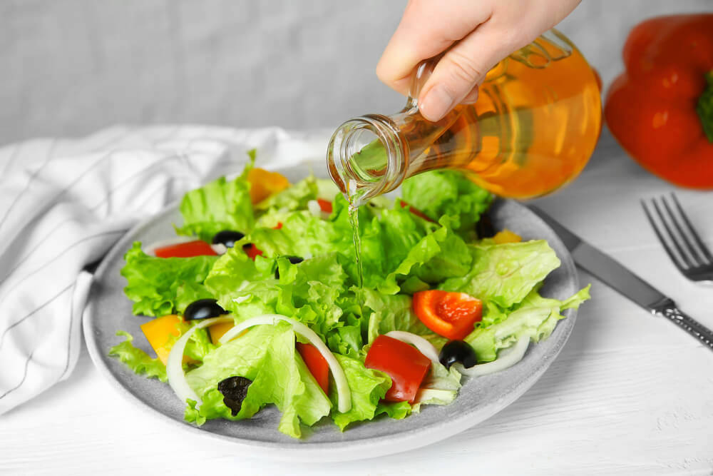 Putting oil on salad