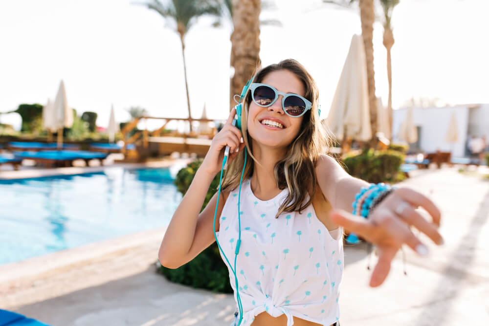 Happy young woman listening to music on her earphones 