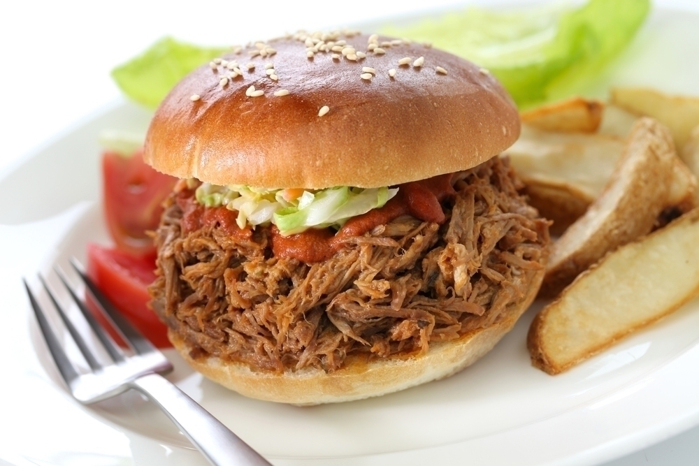 Pulled pork sandwiches with fries on a plate. 