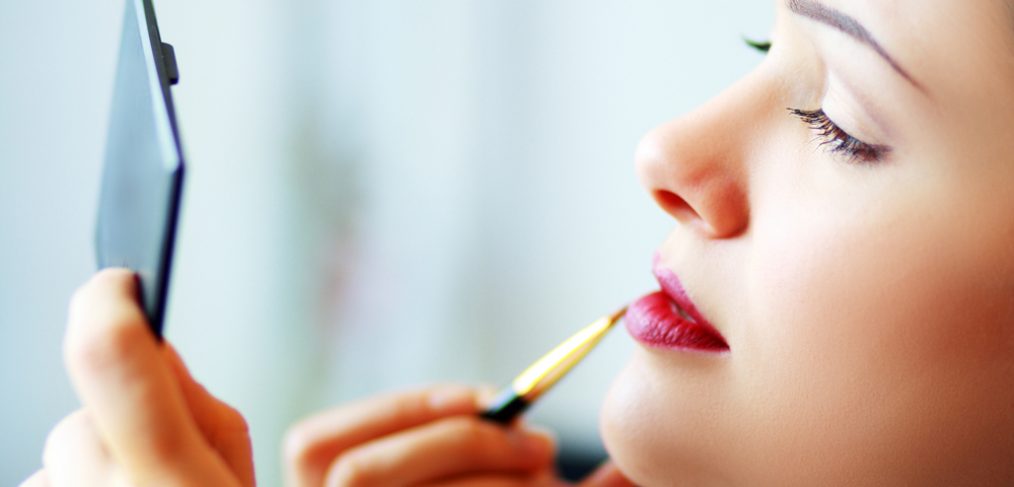 Woman applying lipstick.