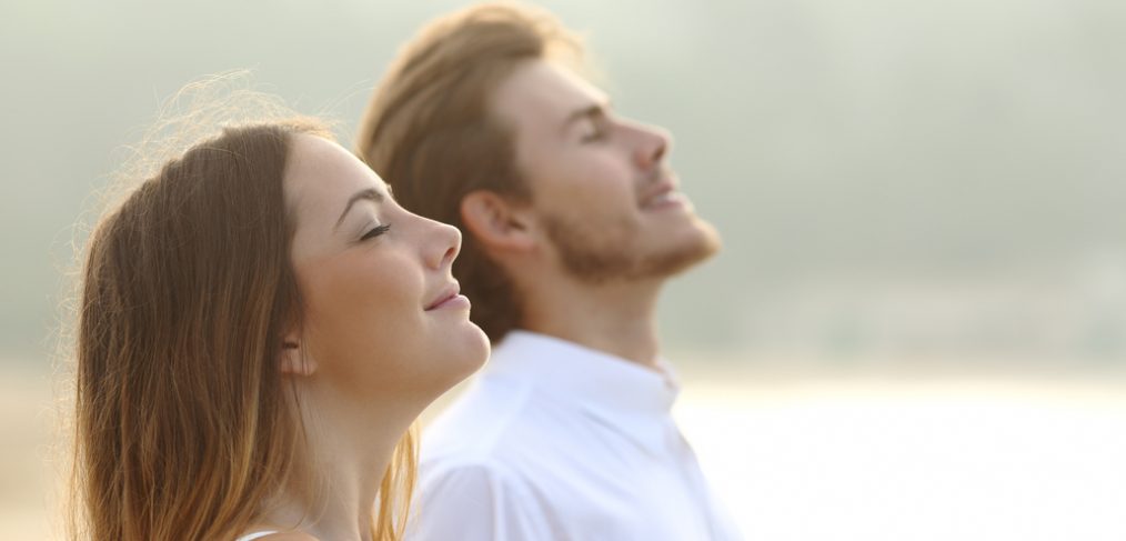 Couple breathing deeply outdoors