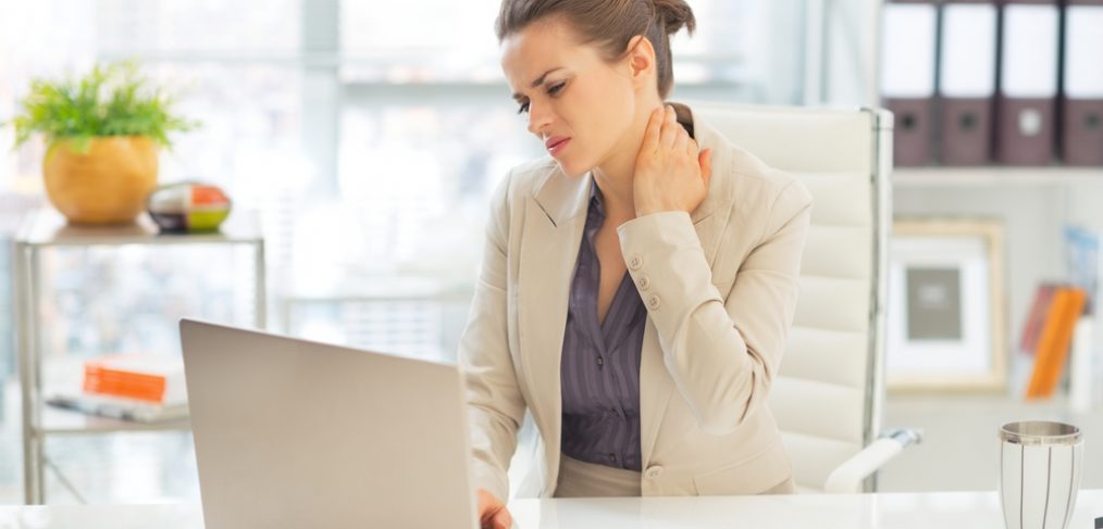 Girl is having neck and back pain during working at the desk