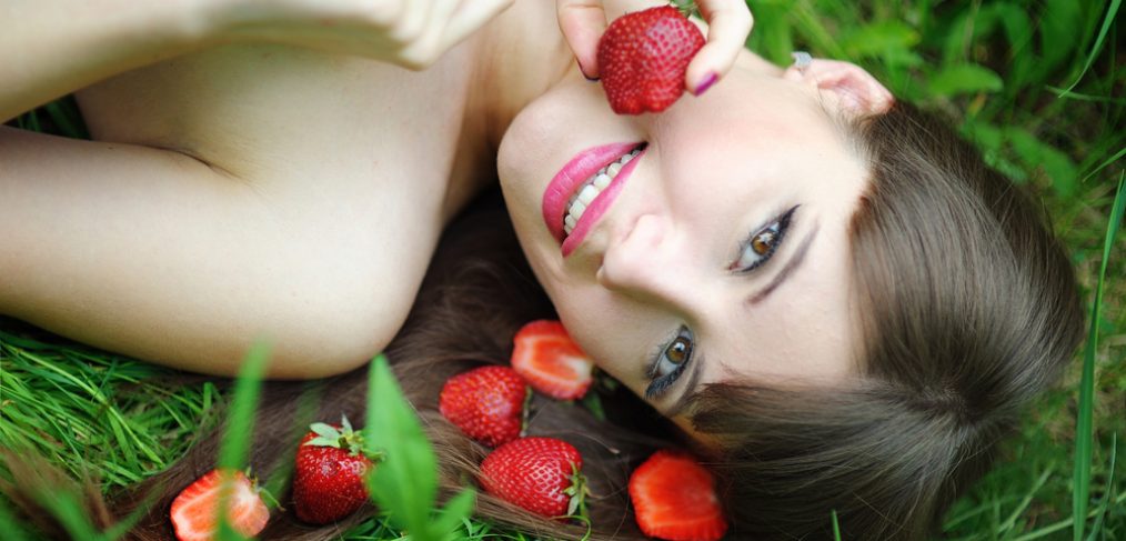 Woman with strawberries in the grass