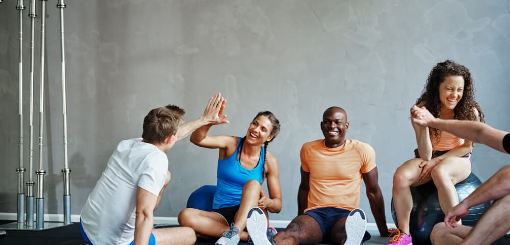 Workout friends high-five each other, resting